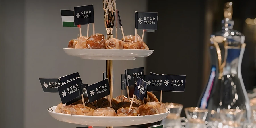 Arabic sweets display with STARTRADER and UAE flags for National Day
