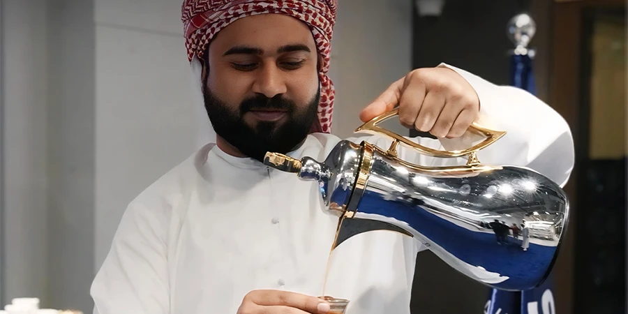 Colleague pouring Arabic coffee at STARTRADER UAE National Day event